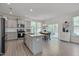 Open kitchen featuring gray cabinets, granite counters, and a dining area with backyard access at 3011 Ginger Hill Ln, Durham, NC 27703