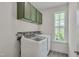 Well-lit laundry room with green cabinets, large window, and modern washer and dryer at 3011 Ginger Hill Ln, Durham, NC 27703