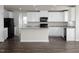 Open kitchen features white cabinets, granite countertops, black appliances, and a central island at 302 Shiloh Way, Mebane, NC 27302