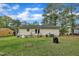 A serene backyard featuring a well-kept lawn and access to the home through sliding glass doors at 308 Plaza Dr, Garner, NC 27529