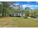 Quaint home features lush green lawn with lots of mature trees surrounding the house at 308 Plaza Dr, Garner, NC 27529