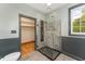 Luxurious bathroom with a glass-enclosed shower, neutral tiles, wainscoting, and a window for natural light at 317 William Dr, Benson, NC 27504