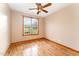 Bright bedroom with hardwood floors, ceiling fan, and large window overlooking a well-maintained yard at 317 William Dr, Benson, NC 27504