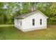 Exterior of the white outbuilding, with vinyl siding, surrounded by a green yard and trees at 317 William Dr, Benson, NC 27504