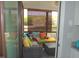Enclosed screened porch area with colorful pillows, wicker furniture, and neutral-toned flooring and walls at 3530 Winding Walk Ct, Raleigh, NC 27616