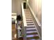 Staircase featuring hardwood steps, white risers, and natural light from nearby windows at 3530 Winding Walk Ct, Raleigh, NC 27616