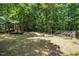 Discover a private backyard featuring three greenhouses nestled amongst lush trees at 3719 W Cornwallis Rd, Durham, NC 27705