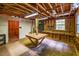 Spacious basement with wooden walls, ceiling beams, and a built in workbench at 3719 W Cornwallis Rd, Durham, NC 27705