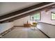 Living area with exposed beams, carpet, a side table, a chair, and beautiful natural light at 3719 W Cornwallis Rd, Durham, NC 27705