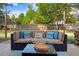 Backyard patio seating area includes cushioned wicker sofa, throw pillows, and coffee table at 387 Windgate Dr, Clayton, NC 27527