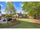 Large grassy backyard with a patio seating area and woodpile at a residential home at 387 Windgate Dr, Clayton, NC 27527