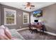 Bedroom with gray walls, desk, daybed, mounted TV and lots of natural light from the windows at 387 Windgate Dr, Clayton, NC 27527