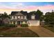 Charming two-story home with a well-manicured lawn, a two-car garage, and covered front porch at 387 Windgate Dr, Clayton, NC 27527