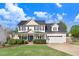 Inviting two-story home with a covered front porch, manicured lawn, and attached two-car garage at 387 Windgate Dr, Clayton, NC 27527