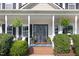 Cozy front porch with charming decor, including hanging plants and a welcome mat, perfect for relaxing at 387 Windgate Dr, Clayton, NC 27527