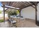This outdoor kitchen area features a grill, bar, and seating, under a wood pergola at 387 Windgate Dr, Clayton, NC 27527