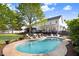 A kidney shaped pool is surrounded by lounge chairs and green grass at 387 Windgate Dr, Clayton, NC 27527