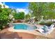 Swimming pool with in-ground lounge chairs, surrounded by lush landscaping and green grass at 387 Windgate Dr, Clayton, NC 27527