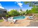 An in-ground swimming pool is surrounded by lounge chairs and white flowering bushes at 387 Windgate Dr, Clayton, NC 27527
