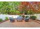 Relaxing brick patio with inviting furniture, surrounded by a privacy fence and lush foliage at 3920 Bentley Brook Dr, Raleigh, NC 27612
