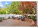 Serene brick patio with a variety of seating options, surrounded by lush landscaping and a privacy fence at 3920 Bentley Brook Dr, Raleigh, NC 27612