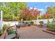Inviting brick patio set amongst lush landscaping with string lights overhead, perfect for outdoor entertaining at 3920 Bentley Brook Dr, Raleigh, NC 27612
