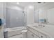 Bathroom with tiled shower over tub, blue tiled accent wall, and a modern vanity with dual faucet sink at 3920 Bentley Brook Dr, Raleigh, NC 27612