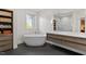 Bathroom with modern, luxurious soaking tub, dual sink vanity, and sleek dark tile flooring at 3920 Bentley Brook Dr, Raleigh, NC 27612