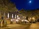 Evening view of a brick townhome with garage, well-lit entrance, and mature landscaping at 3920 Bentley Brook Dr, Raleigh, NC 27612
