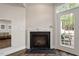 Modern black fireplace and mantle in a finished basement with access to the outside at 3920 Bentley Brook Dr, Raleigh, NC 27612