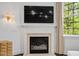Cozy fireplace with a decorative mantel, a mounted television, and large windows providing natural light at 3920 Bentley Brook Dr, Raleigh, NC 27612