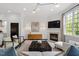 Open living room with a fireplace, contemporary decor, and large windows at 3920 Bentley Brook Dr, Raleigh, NC 27612