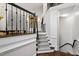 Elegant staircase featuring a black railing, carpeted steps, and hardwood flooring at 3920 Bentley Brook Dr, Raleigh, NC 27612