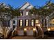 Elegant brick townhome with dark shutters and garage, enhanced by outdoor lighting at dusk at 3920 Bentley Brook Dr, Raleigh, NC 27612