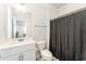 Clean bathroom features a single sink vanity with toilet and shower with curtain in the background at 4005 Sierra Pelona Dr, Raleigh, NC 27616
