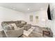 Comfortable living room featuring a plush gray sectional, ottoman, and an exterior door at 4005 Sierra Pelona Dr, Raleigh, NC 27616