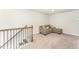 Cozy loft area with a comfortable gray couch and staircase with wooden banister at 4005 Sierra Pelona Dr, Raleigh, NC 27616