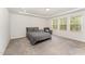 Relaxing bedroom with soft carpet, tray ceiling, and natural light from three large windows at 4005 Sierra Pelona Dr, Raleigh, NC 27616