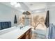 Neutral bathroom featuring decorative shower curtain, double vanity, framed mirror, open shelving, and modern lighting at 416 Glenview Ln, Durham, NC 27703