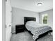 Well-lit bedroom featuring a black bed frame, geometric patterned comforter, gray carpet and a window with natural light at 416 Glenview Ln, Durham, NC 27703
