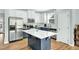 Modern kitchen with white cabinets, an island, stainless steel appliances, and ample counter space for cooking at 416 Glenview Ln, Durham, NC 27703