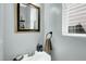 Close-up of a modern powder room featuring a pedestal sink and a decorative mirror at 416 Glenview Ln, Durham, NC 27703