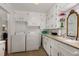 Bright laundry room with a sink, cabinets, shelves, and modern washer and dryer, designed for convenience at 431 Waddill St, Henderson, NC 27536