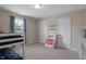 A simple bedroom with a bunk bed, a window with curtains, and carpeted floors at 46 Twelve Oaks Dr, Willow Springs, NC 27592