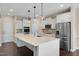 Modern kitchen with stainless appliances, white cabinetry, and a large quartz island at 46 Twelve Oaks Dr, Willow Springs, NC 27592