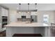 Modern kitchen with stainless appliances, white cabinetry, and a large quartz island at 46 Twelve Oaks Dr, Willow Springs, NC 27592