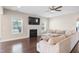 Spacious living room featuring a fireplace, dark wood floors, and a comfortable beige sectional couch at 46 Twelve Oaks Dr, Willow Springs, NC 27592