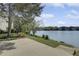Picturesque backyard with a patio offering stunning lake views, surrounded by lush greenery and mature trees at 512 N Waters Edge Dr, Durham, NC 27703