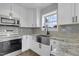 Modern kitchen features granite countertops, stainless steel appliances, and a farmhouse sink at 512 N Waters Edge Dr, Durham, NC 27703