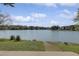 Expansive lake view from the property with a grassy shoreline and wooden steps at 512 N Waters Edge Dr, Durham, NC 27703